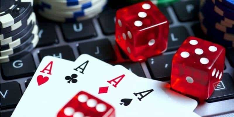 dice, cards, and poker chips on a laptop keyboard