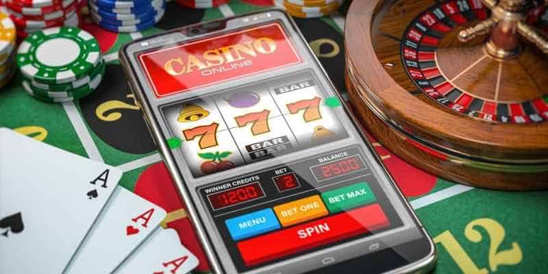 smartphone with online casino app among retail casino table game paraphernalia