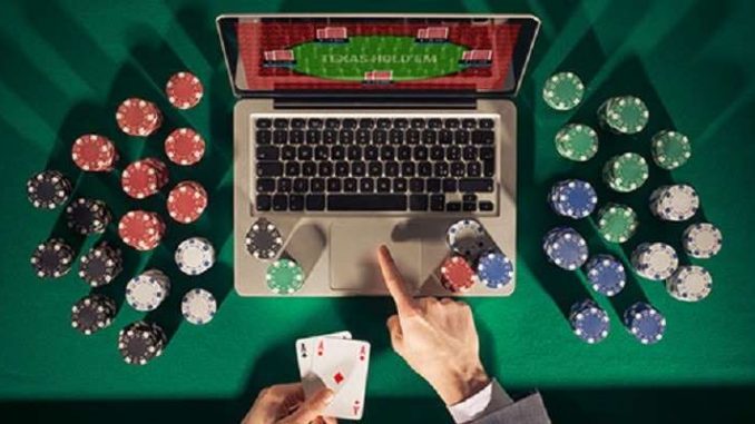 online poker takes off due to covid-19 card room closures man playing online poker on a laptop computer with chips stacked around the table