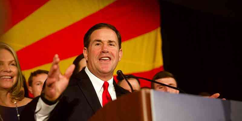 az governor doug ducey smiling at podium