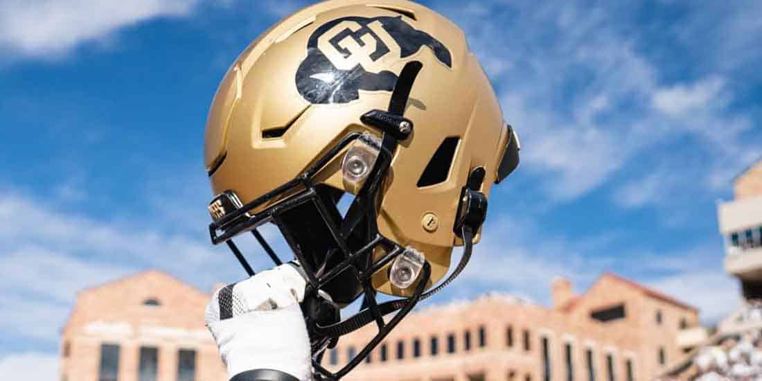 a Colorado Buffaloes helmet being hoisted into the air